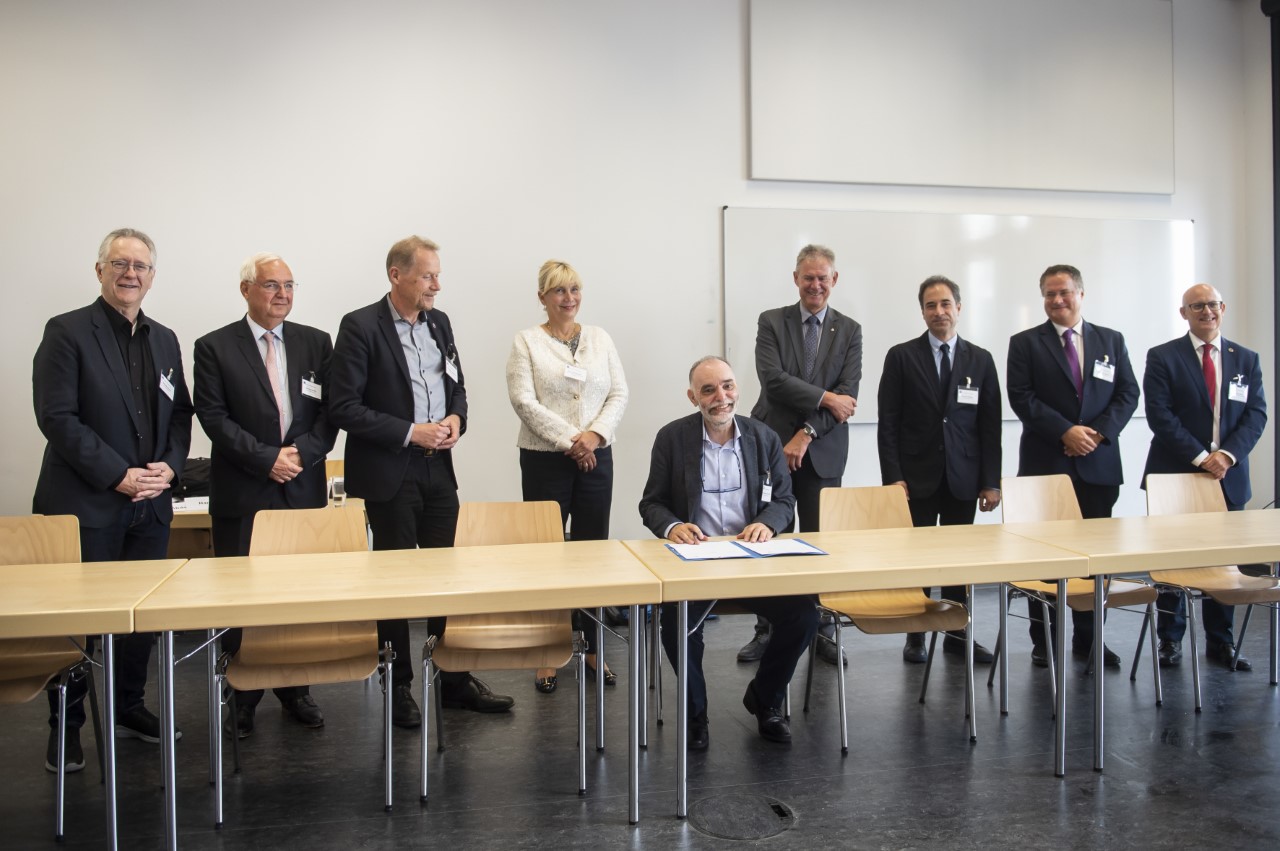 University leaders stand to congratulate Georgia Tech-Lorraine president Abdallah Ougazzaden, seated, on the official signing of Georgia Tech-Lorraine into NeurotechEU. Photo: Barbara Frommann, University of Bonn.